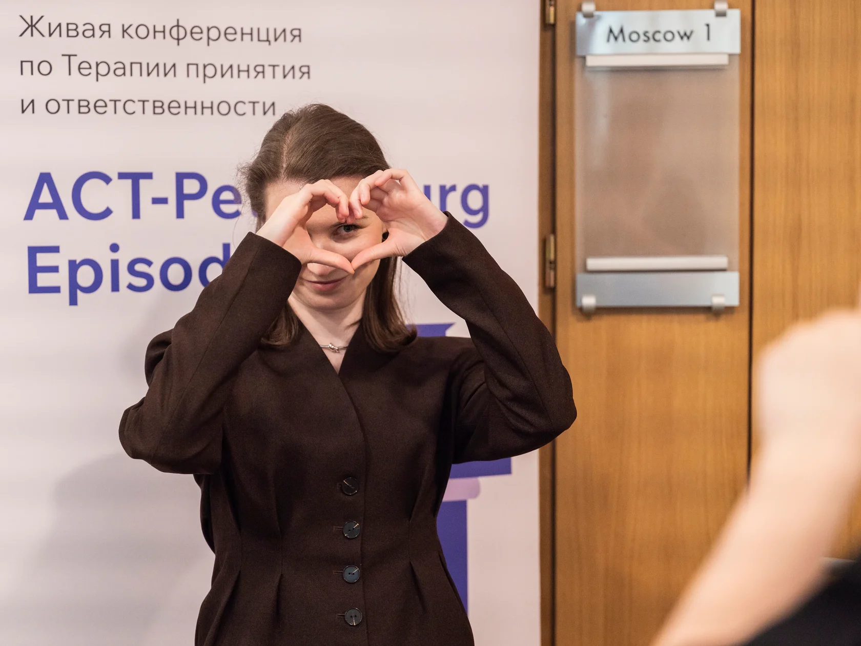 Эксперт конференции показывает жест в форме сердца