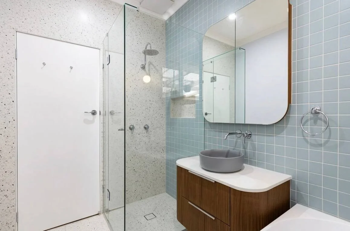 Full bathroom view with freestanding tub, frameless glass shower, walnut vanity and blue subway tile — Redmond WA bathroom remodel