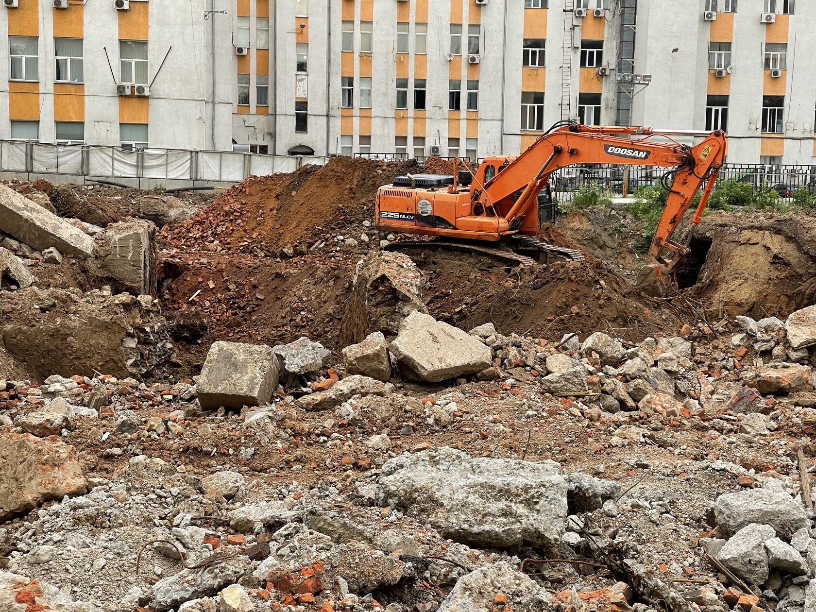 Разработка котлована под фундамент здания гусеничным экскаватором в Москве