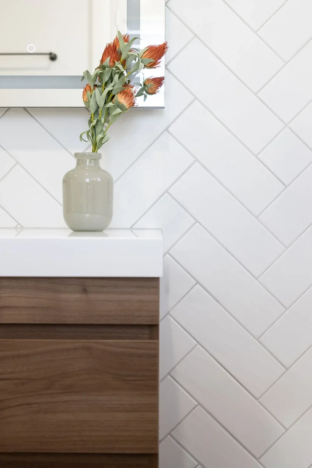 White herringbone subway tile detail with walnut vanity edge and LED mirror — bathroom remodeling Issaquah WA