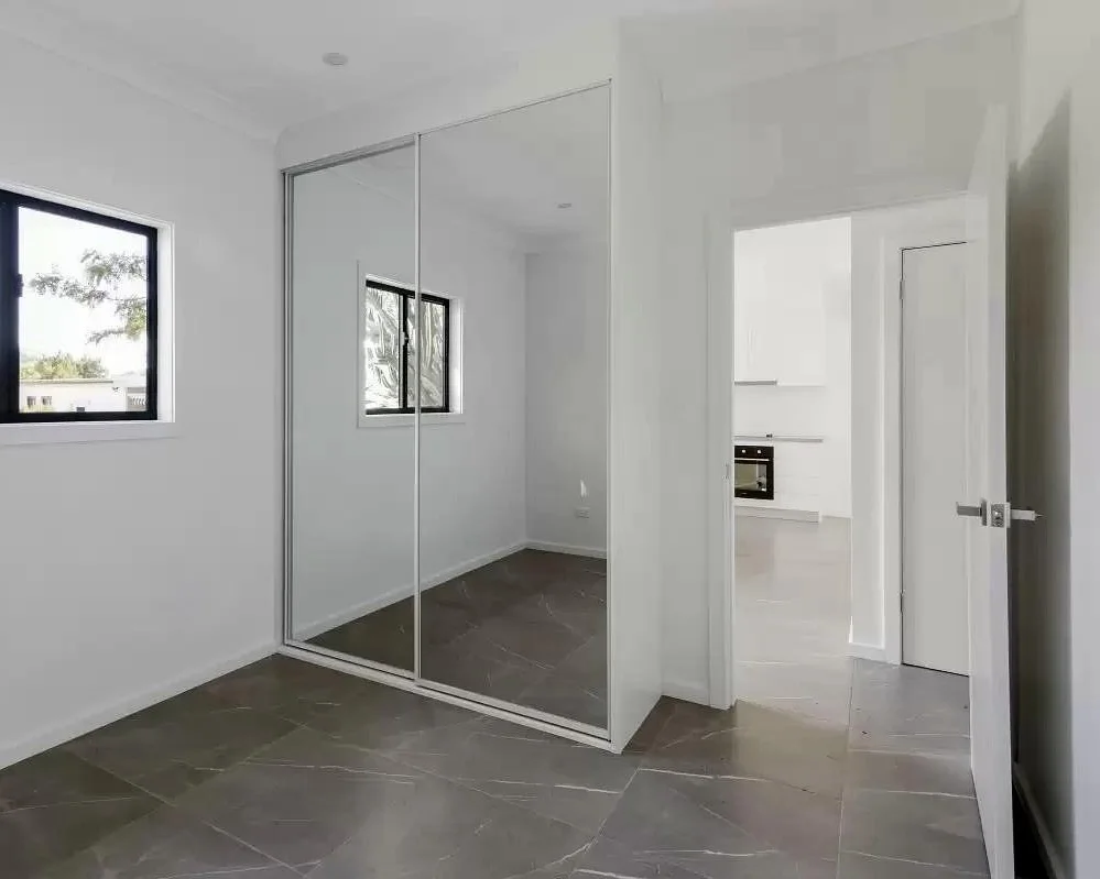 Modern DADU bedroom Edmonds — mirrored sliding closet doors marble-look porcelain floor