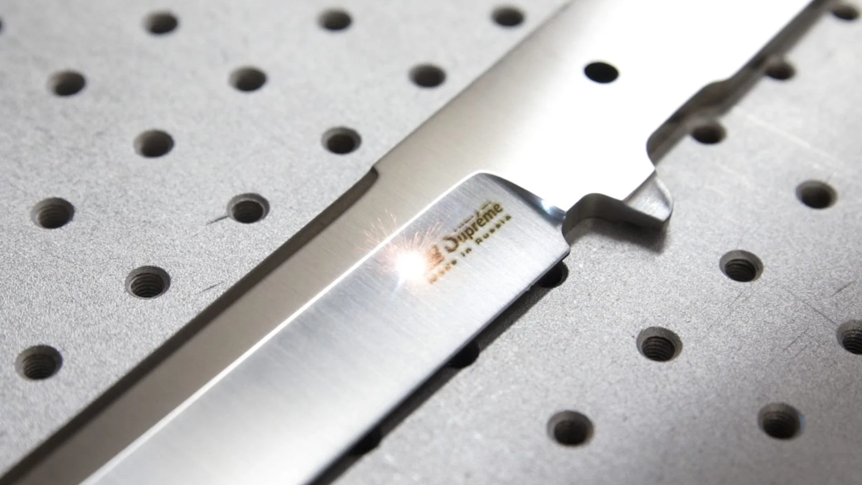 Laser marking a Kizlyar Supreme blade in the workshop