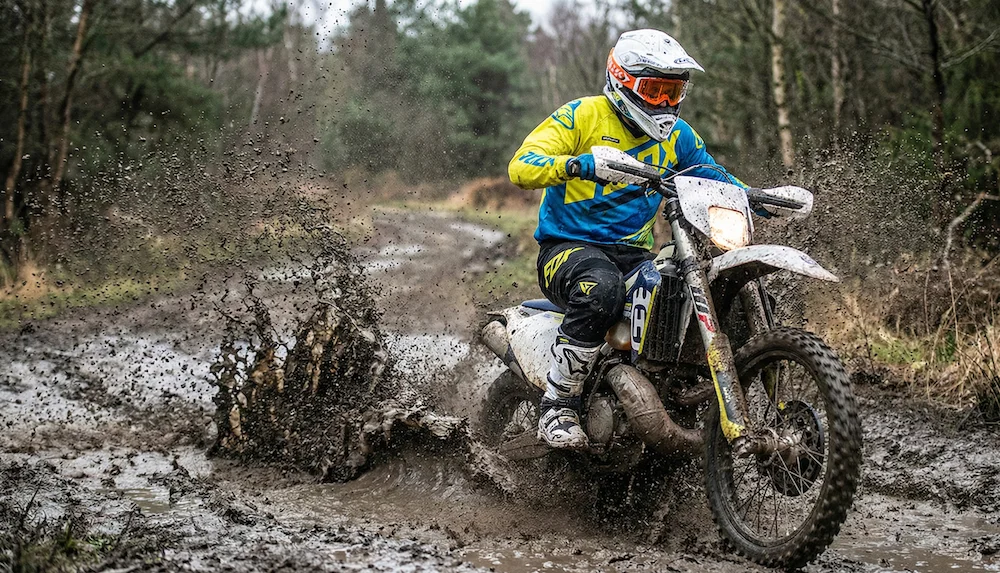 райдер проезжает лужу на эндуро во время проката