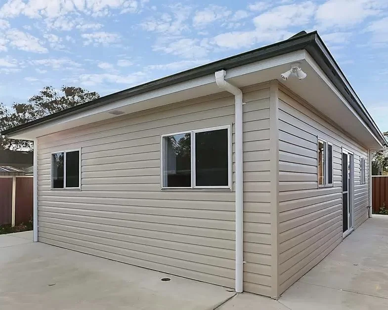 720 sq ft detached ADU exterior Renton WA — sand beige fiber cement siding gable roof concrete patio backyard cottage