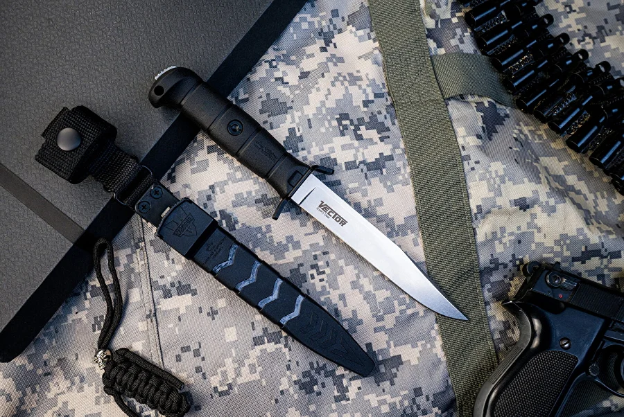 Black Kizlyar Supreme Vector knife and sheath on camouflage fabric