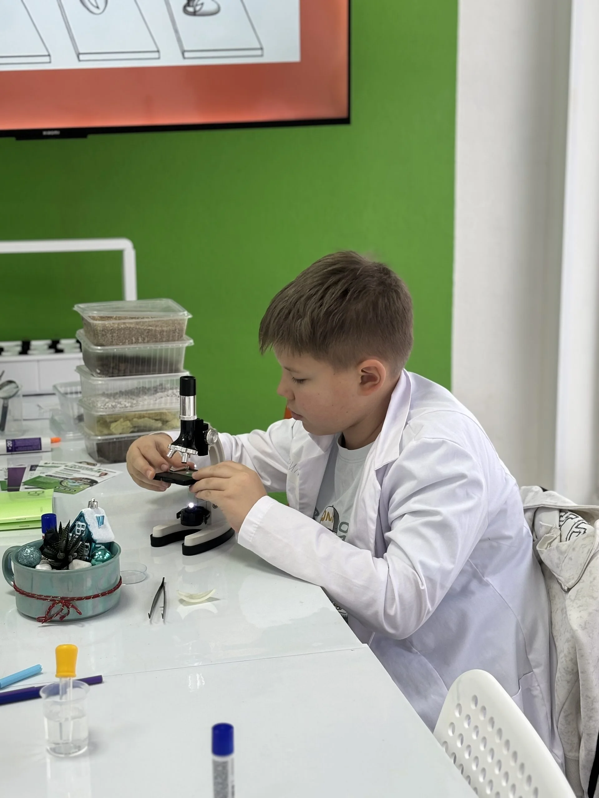 Ребёнок работает с микроскопом