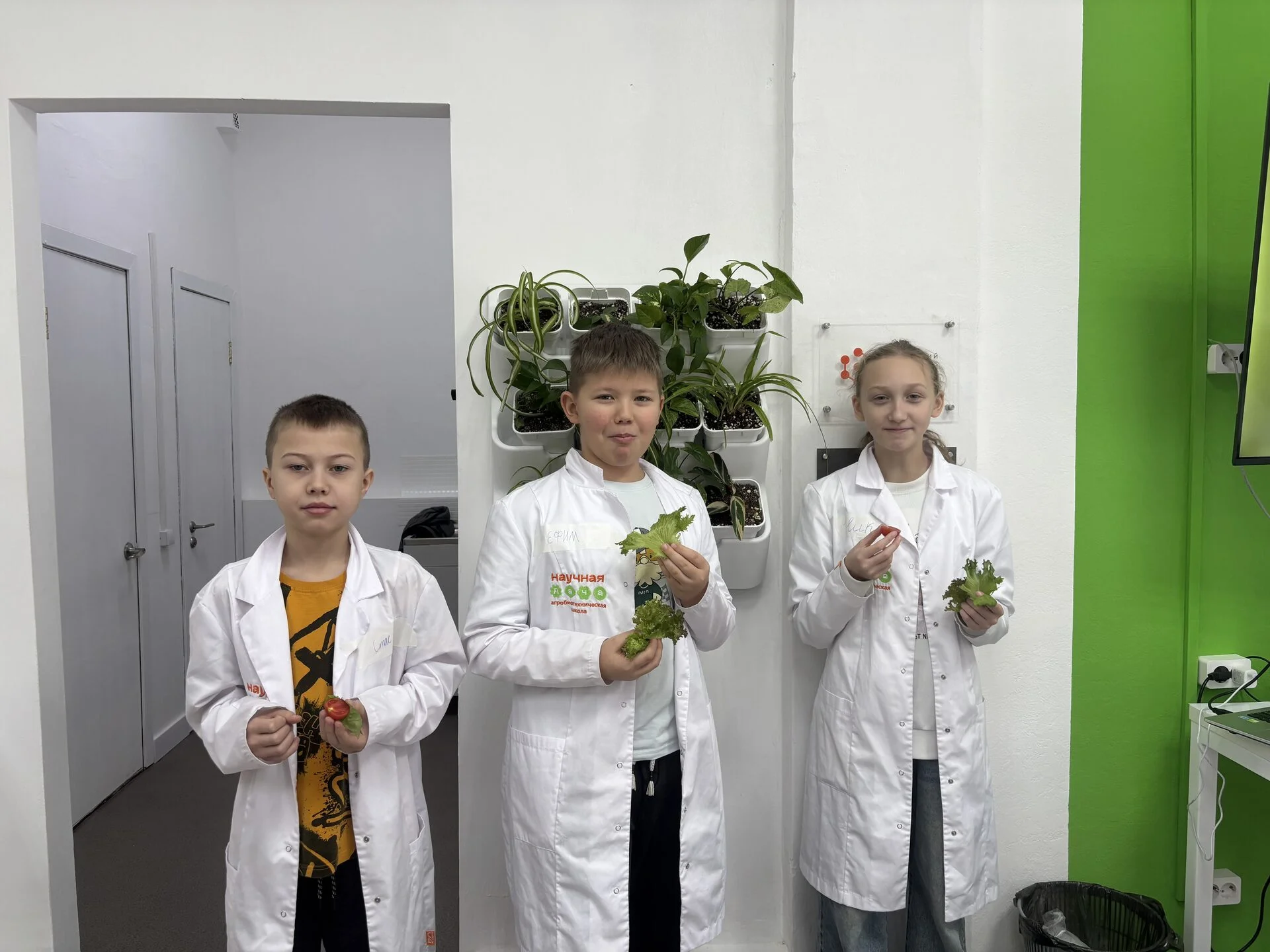 Дети показывают урожай с сити-фермы