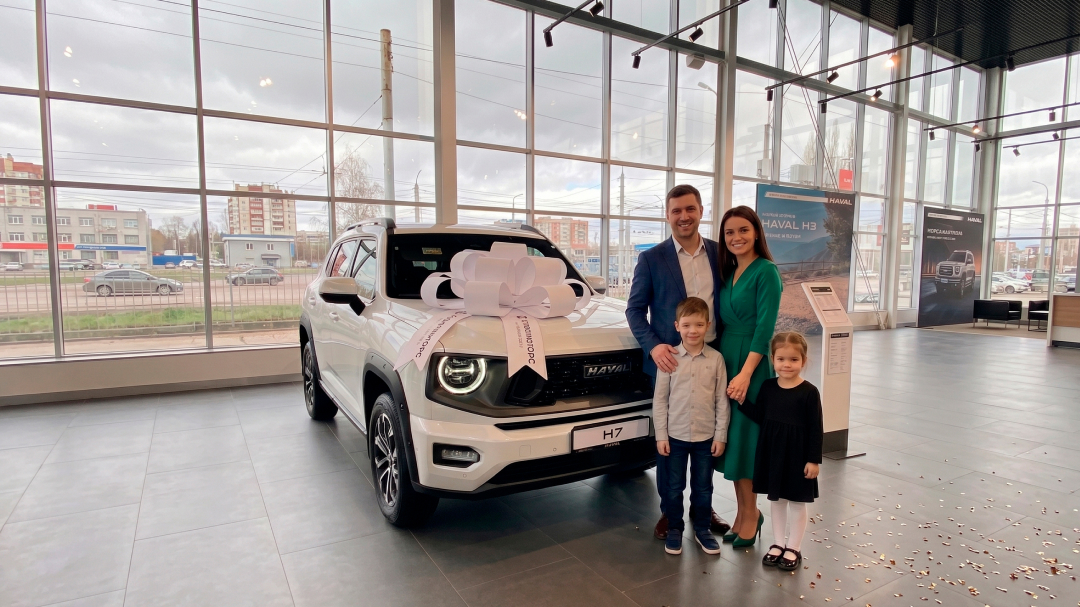 Посетители рядом с белым HAVAL H7 в дилерском центре