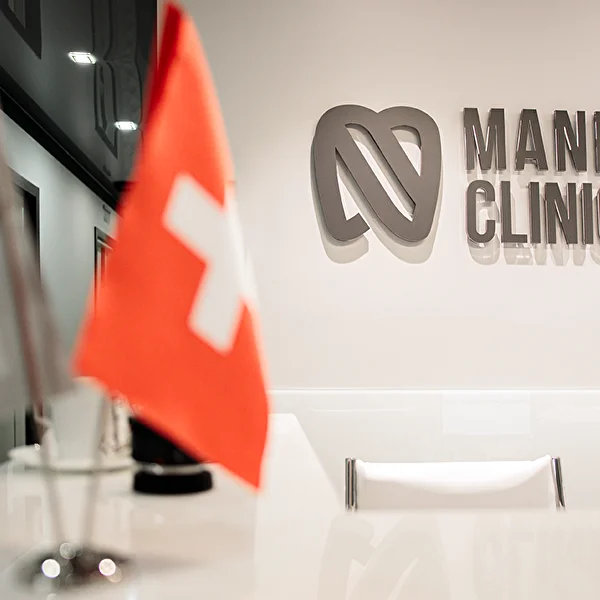 Вход в Mane Clinic: логотип клиники на стене