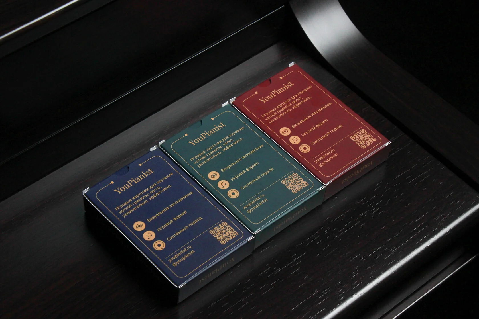 Обратная сторона трёх коробок YouPianist Trainers с описанием и QR-кодом