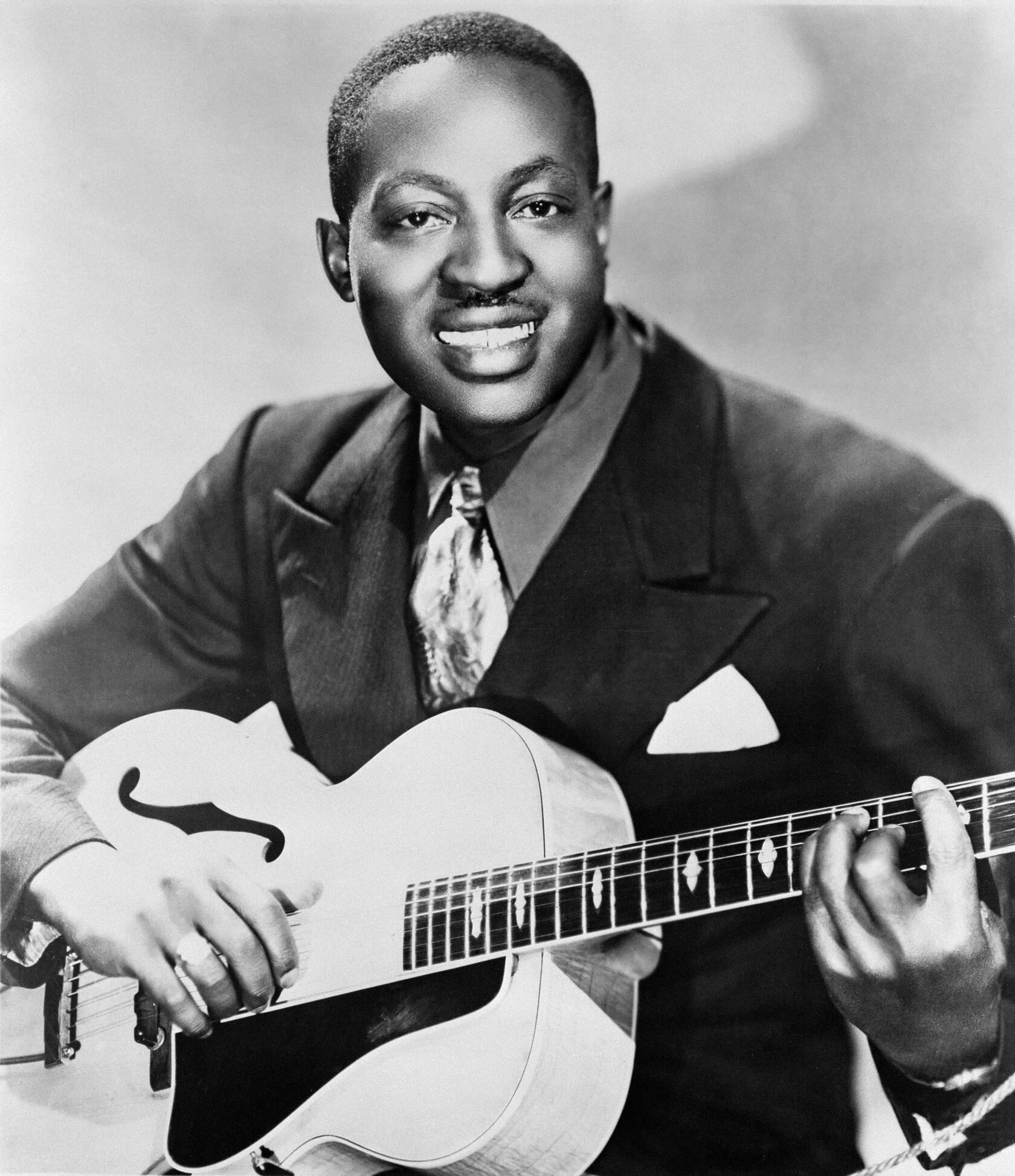 Big Bill Broonzy в костюме с гитарой, рекламная фотография 1951 года