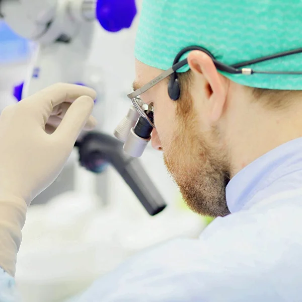 Врач Mane Clinic работает с микроскопом