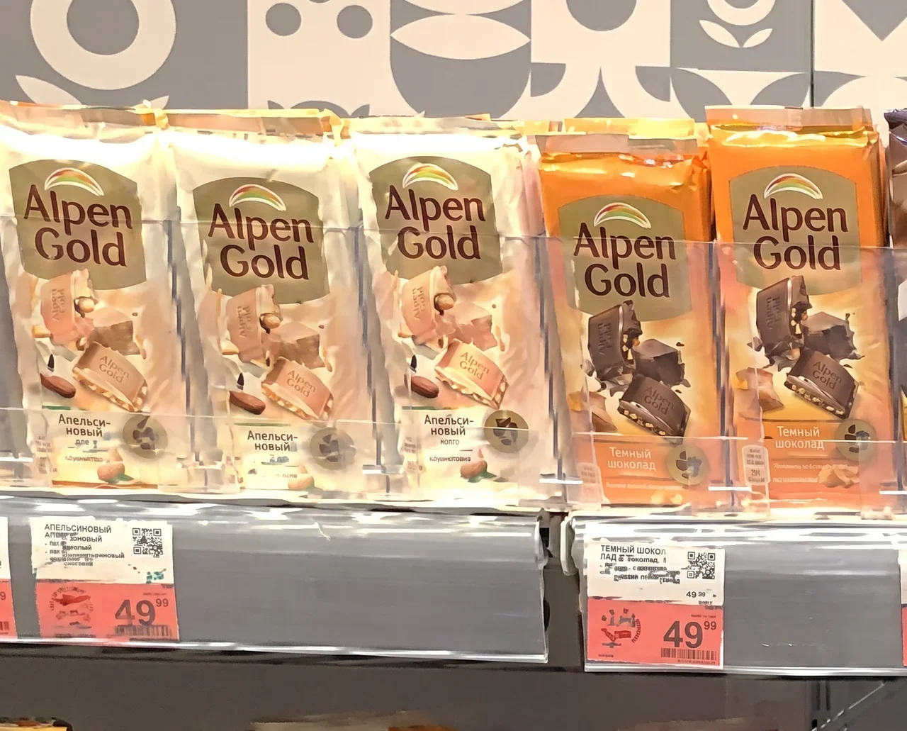 Ценники под шоколадом Alpen Gold на полке торгового зала