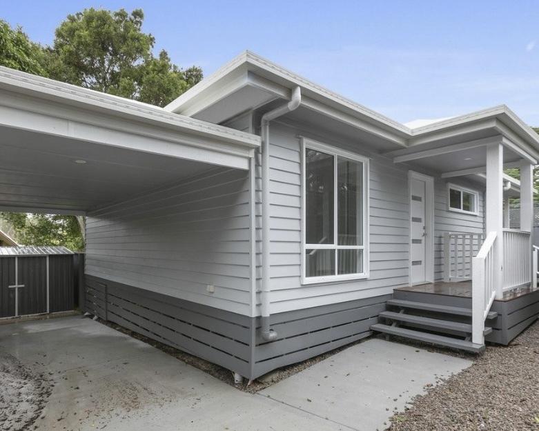 550 sq ft DADU exterior with carport Bothell WA — grey fiber cement siding dark charcoal trim
