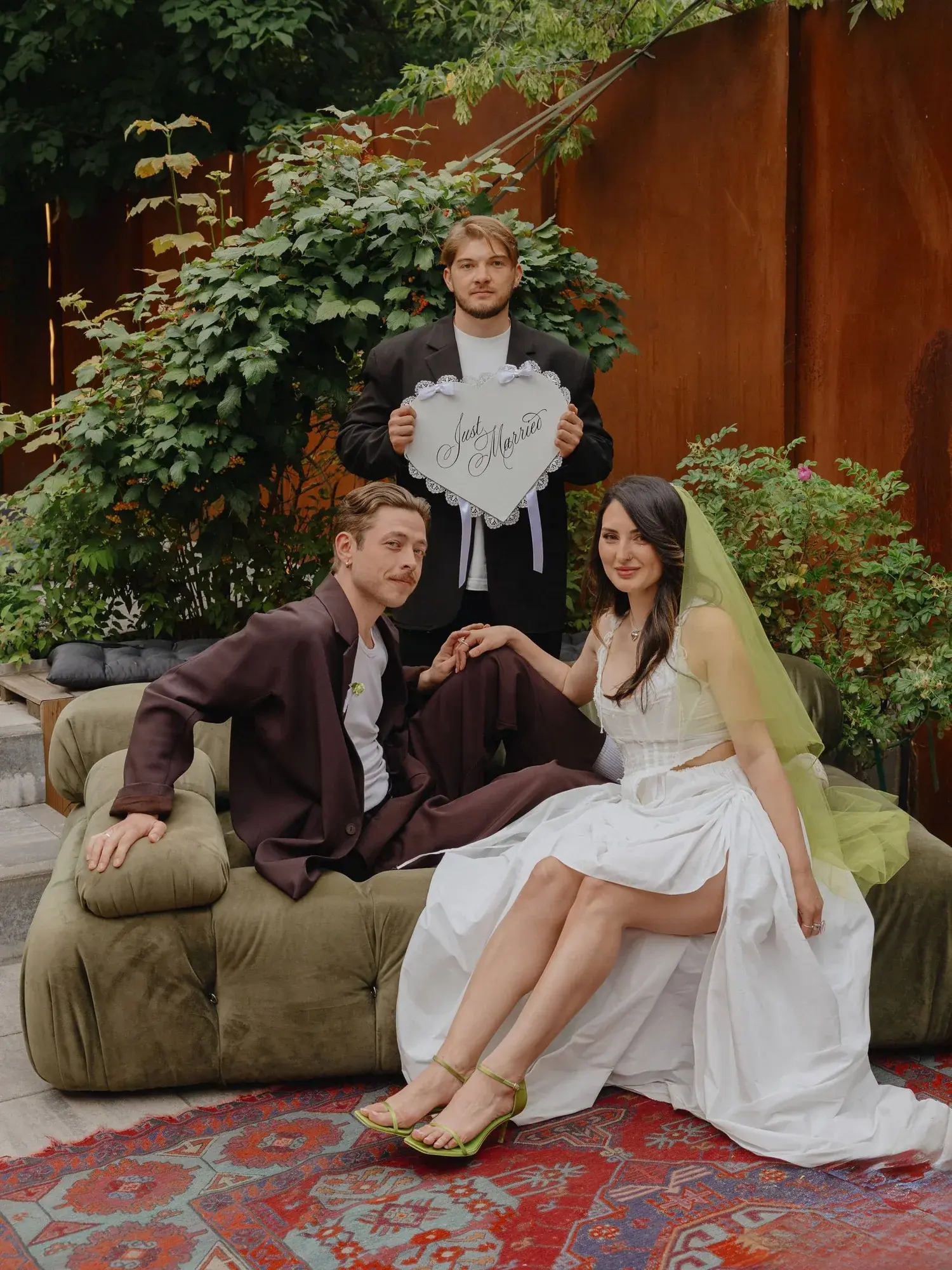 Этери и Сергей на диване с табличкой Just Married