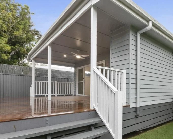Covered wraparound deck DADU Bothell — timber decking ceiling fan recessed lighting white railing