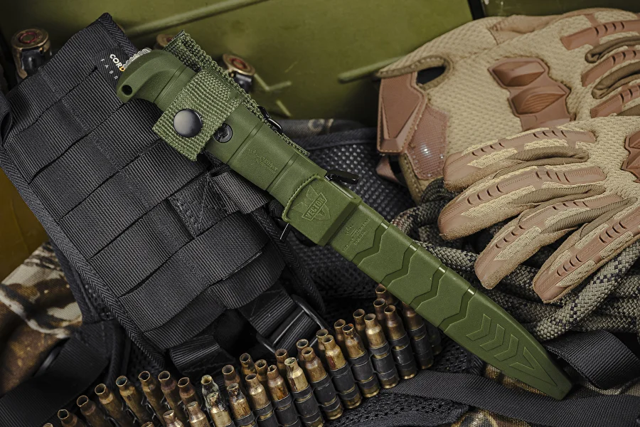 Olive Kizlyar Supreme Vector knife positioned beside tactical equipment