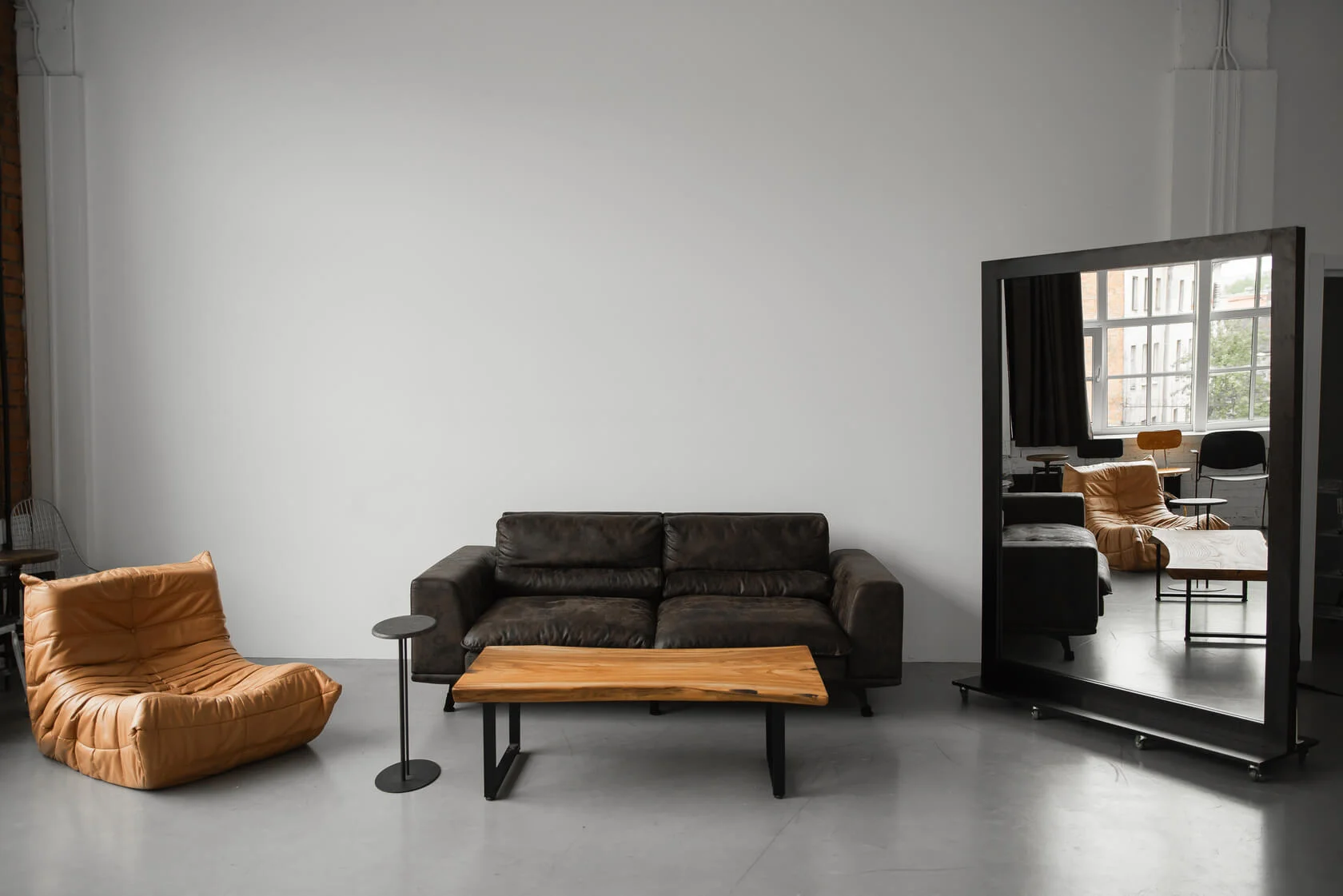 Уютная лаунж-зона с кожаными диванами и деревянным столом для неформального общения