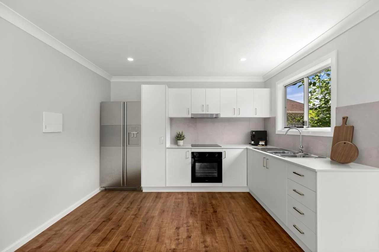 Rental DADU kitchen Bothell — white cabinets quartz countertops LVP flooring stainless appliances