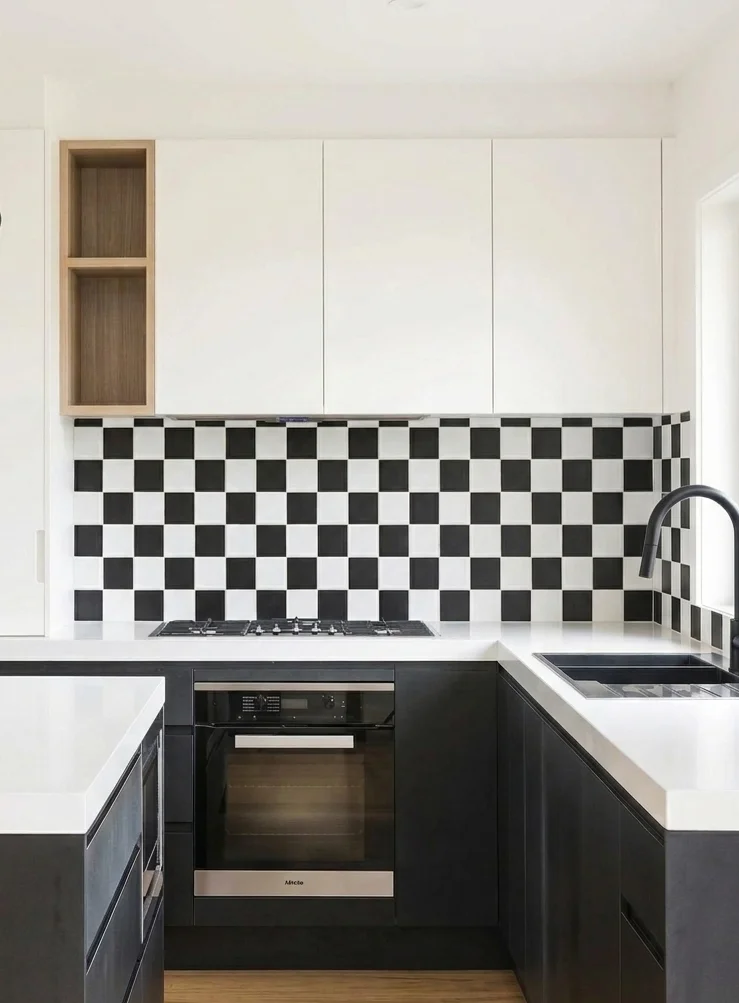 Corner view of Miele gas cooktop, built-in oven, zellige backsplash, and matte black handleless cabinets — kitchen remodeling Renton WA