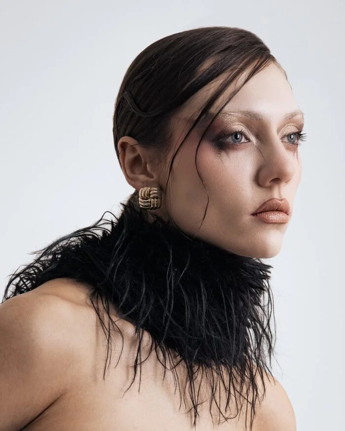 Beauty editorial portrait with a sculptural black feather collar