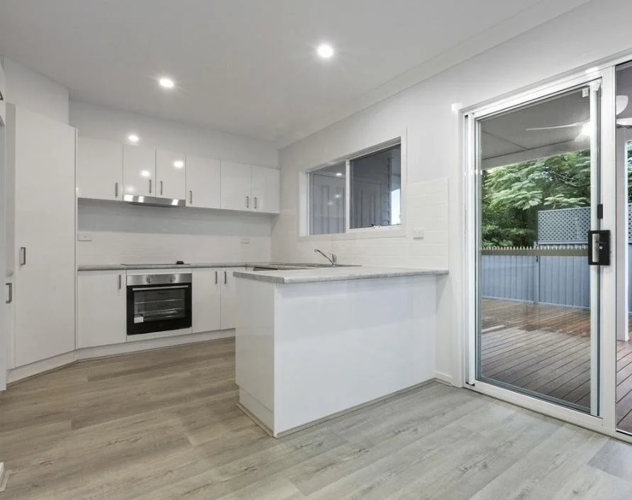 DADU kitchen Bothell — white cabinets island LVP flooring sliding door to deck