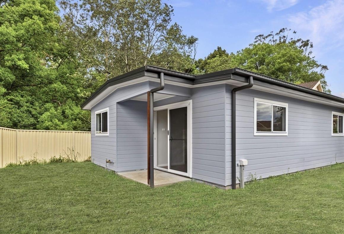 680 sq ft rental DADU exterior Bothell WA — grey-blue fiber cement siding flat roof dark fascia