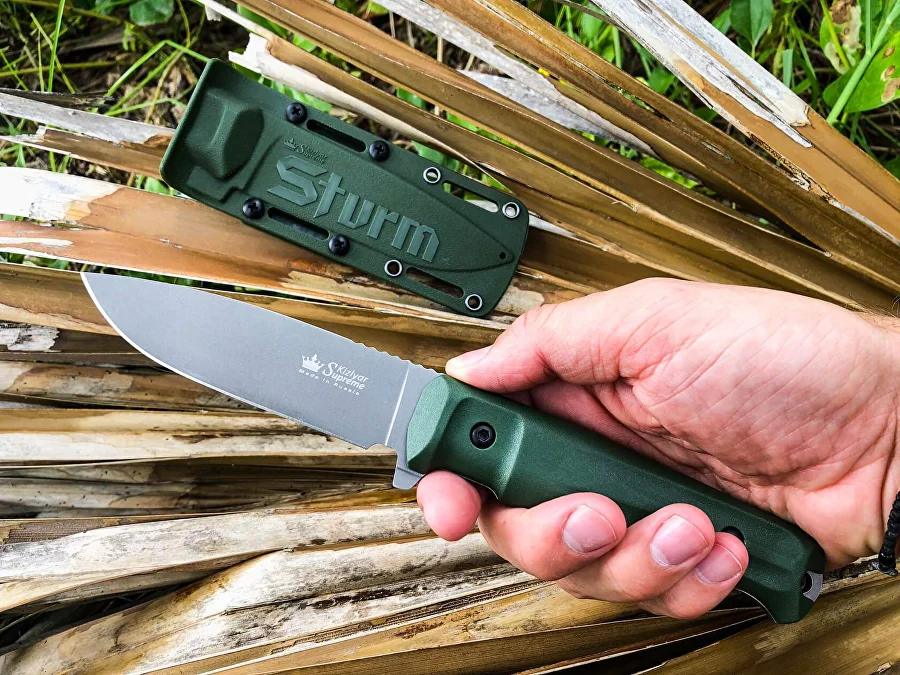 Olive Sturm knife used outdoors among palm leaves
