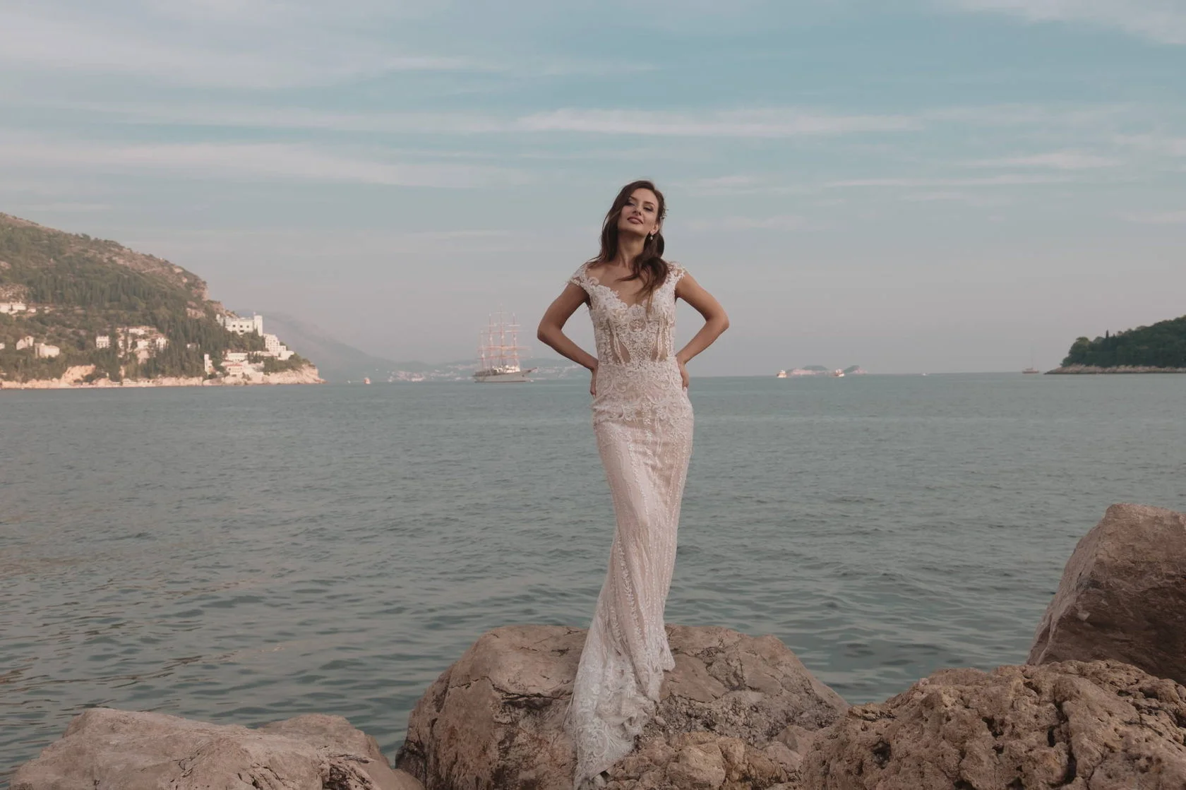 Bride in a lace gown on the rocks by the sea in Dubrovnik